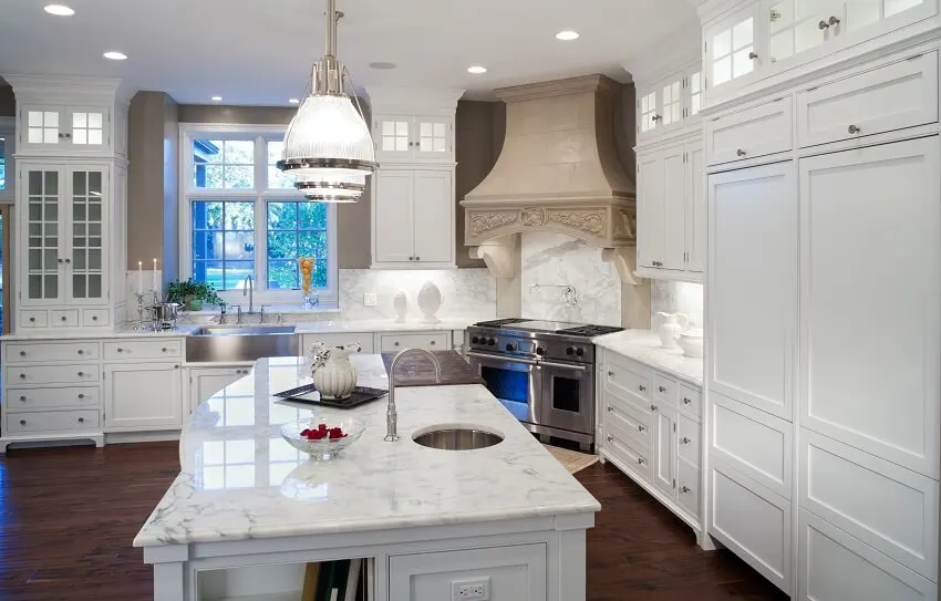 White marble kitchen with stainless sink and hardware and white enamel custom cabinets