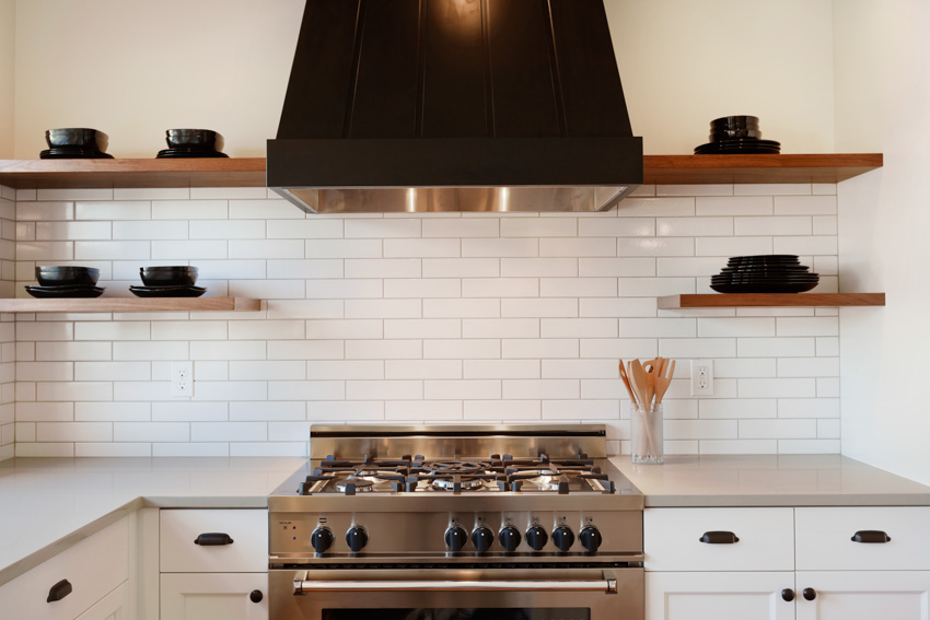 White tile kitchen backsplash countertop shelves hood stove