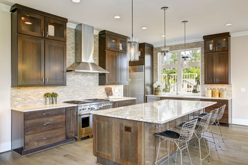 Wood cabinets and floors tiled kitchen backsplash hood center island with seating windows countertop