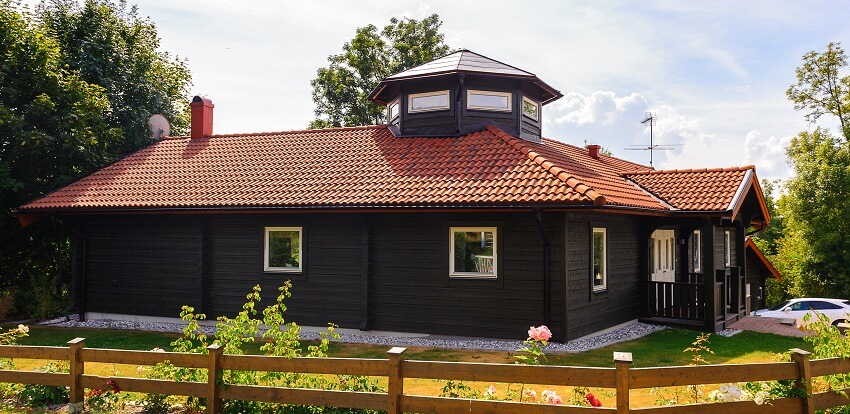 Wooden brown house with yard and fence