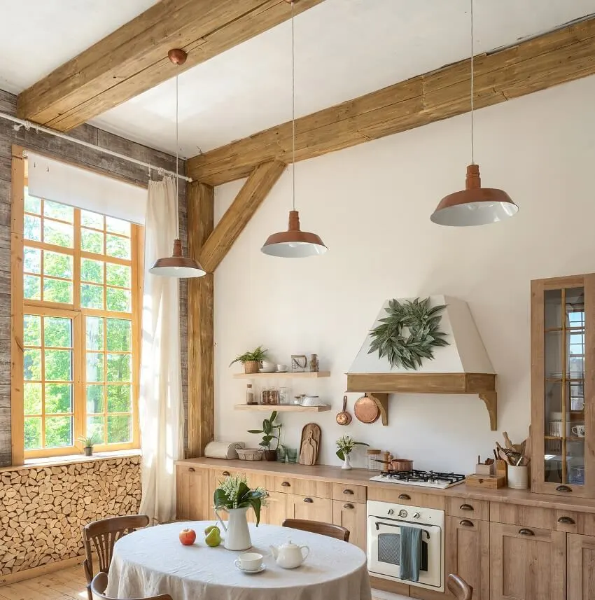 Wooden kitchen with cabinets tablecloth on dinner table oven appliance kitchenware supplies windows and pendant lights