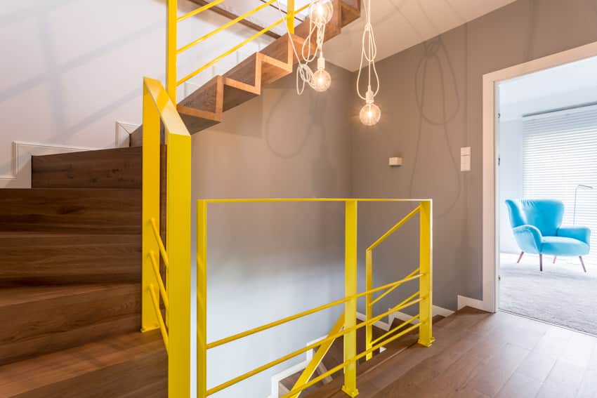 Yellow painted stair railing wood floor concrete wall hanging lights