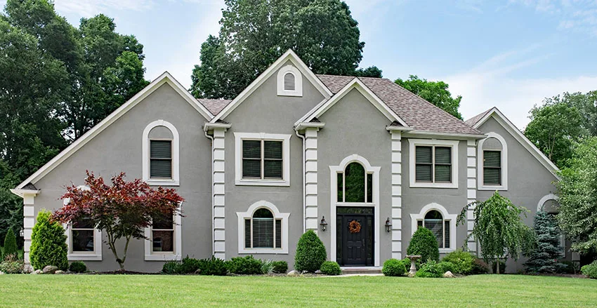 Stucco house with gray paint large front lawn