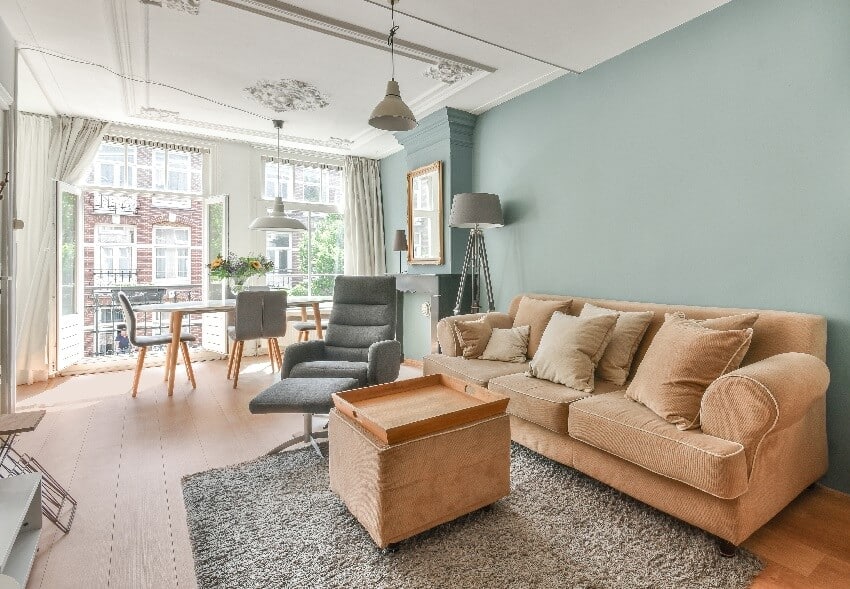 Apartment interior with blue walls and decorated ceiling and an open balcony door