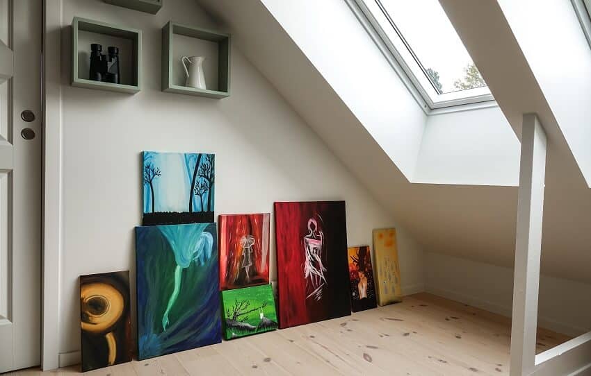 Art collection in modern loft apartment with wood floors and natural light through a glass window