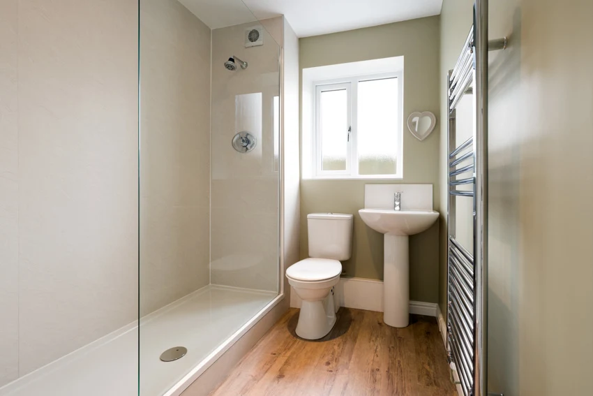 Bathroom shower area wood flooring window toilet sink