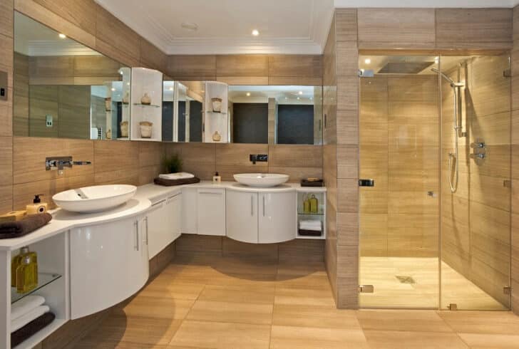 Bathroom Suite In A Luxury Home With A Large Shower Unit Curved White Cabinets With His And Hers Basins Fossil Marble Floor And Walls Mirrors And Shelving Above The Van 728x490 