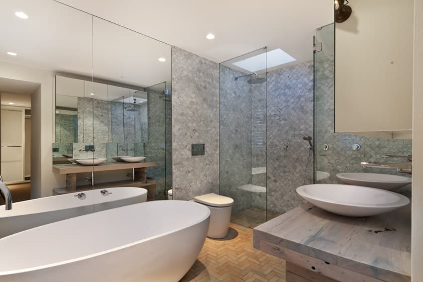 Bathroom with tub skylight shower area glass door sink mirror toilet recessed lighting