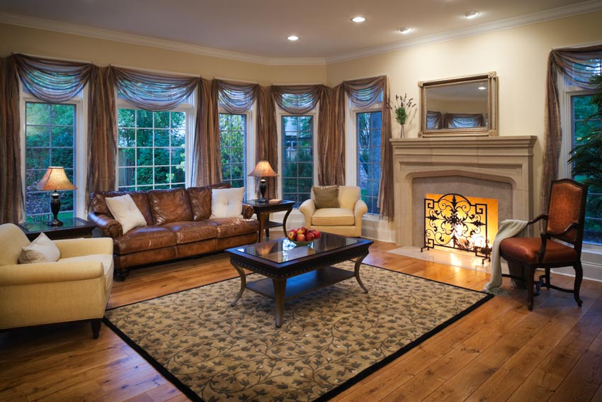Beautiful living room fireplace mantel rug wood floor windows curtain leather sofa chairs recessed lighting
