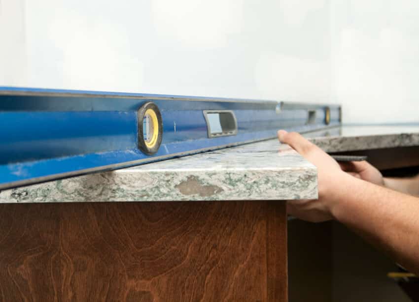Contractor measuring installing granite countertop overlay