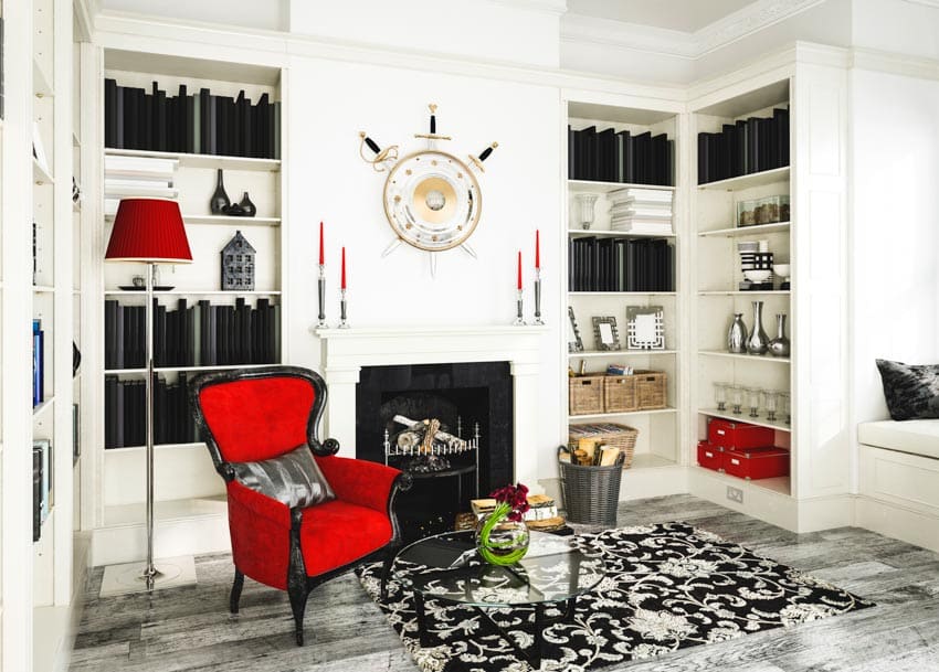 Lamp with red shade, patterned rug and marble floor fireplace