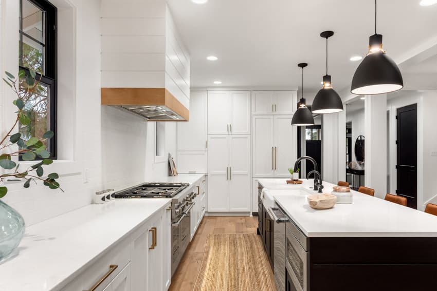 Modern farmhouse kitchen with white surface countertops and black island