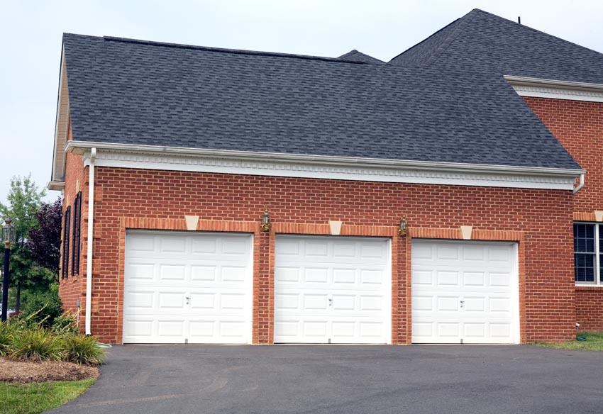 Garage with shingle roof and asphalt driveway
