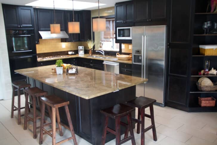 Marble Vs Granite Countertops   Granite Countertop Center Island Black Kitchen Cabinets Stools Backsplash Hanging Light Is 728x486 