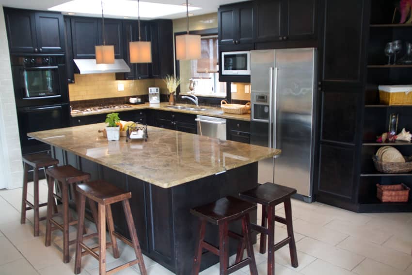 Granite countertop center island black kitchen cabinets stools backsplash hanging light