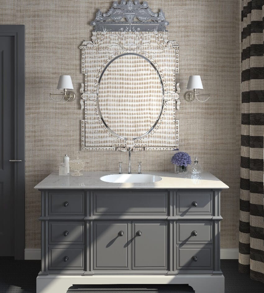 Grey cabinets a sink a striped curtain and sconce fixtures in a bathroom