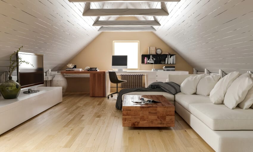 Home attic interior with cream white paint, slanted wall and white sofa