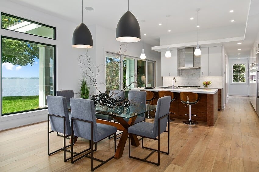 Kitchen and dining with picture windows pendant lights, island with bar stools, brick backsplash