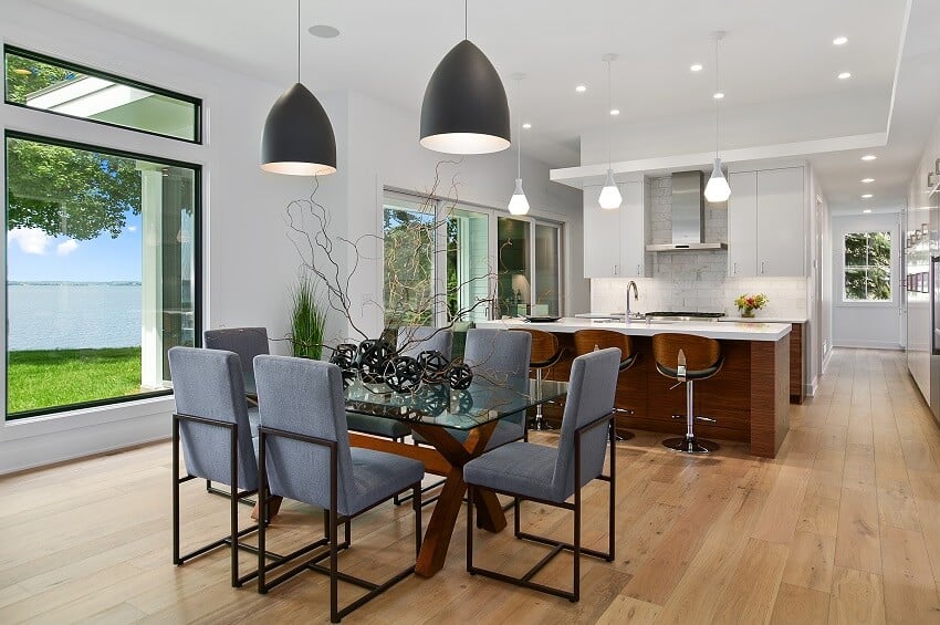 Kitchen and dining with picture windows pendant lights, island with bar stools, brick backsplash 