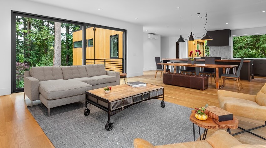 Stylish room with large grey rug and couch with rolling cart