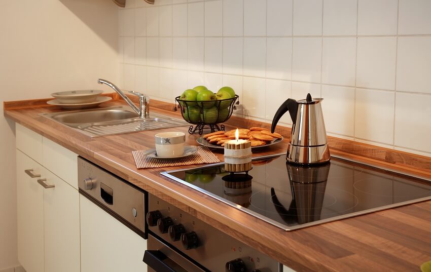 Kitchen with essentials on stained countertop with range 