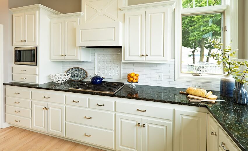 Kitchen with decors and burner on countertop brick backsplash white cabinets window and light wood floors