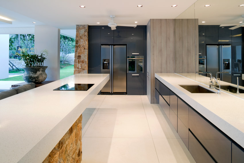 Kitchen with low ceiling, white solid surface countertop, center island, recessed lighting, and tile floor