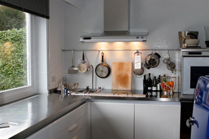 Kitchen with metal countertop hood window white cabinet