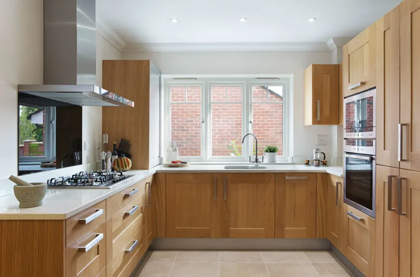 Kitchen with modular units hood wood cabinets countertop window