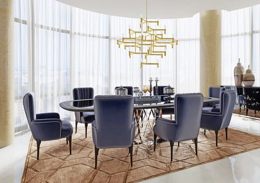 Large dining table with blue satin armchairs pendant light marble floors decors and panoramic windows with sheer drapes in a luxurious apartment