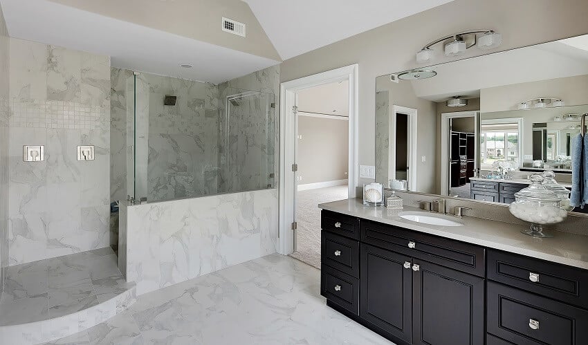 Large walk in shower with beautiful marble walls black cabinets and wall mirror 