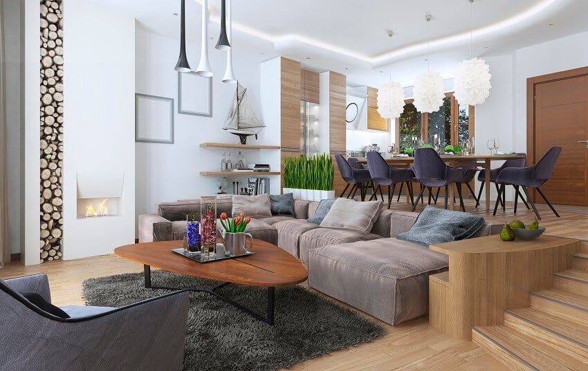 Room in a loft style blending into the kitchen with large corner sofa, shelves with soft chair with a floor lamp 