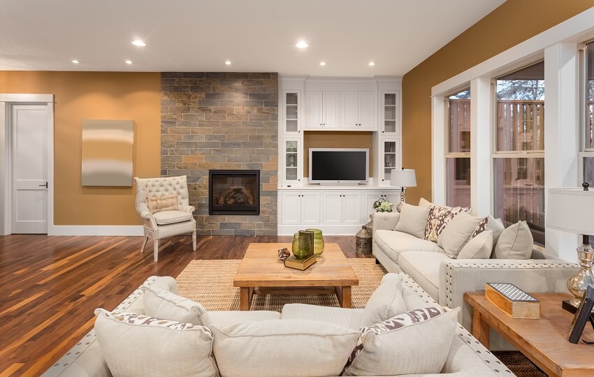 Living room interior with hardwood floors fireplace on brickwall sofa pillows coffee table and built in cabinets