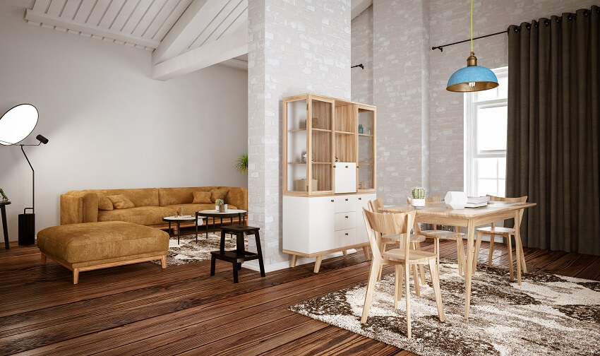 Loft room with brick wall and column beams light wood dining table cabinet shelves pendant light and hardwood floors