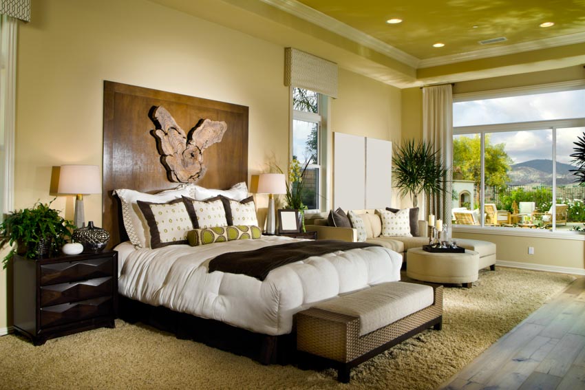 Masters bedroom high pile carpet headboard windows recessed lighting nightstand indoor plant mirror lamp shade