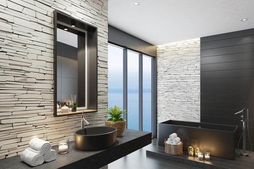 Matte black bathroom fixtures tub windows sink countertop accent wall mirror