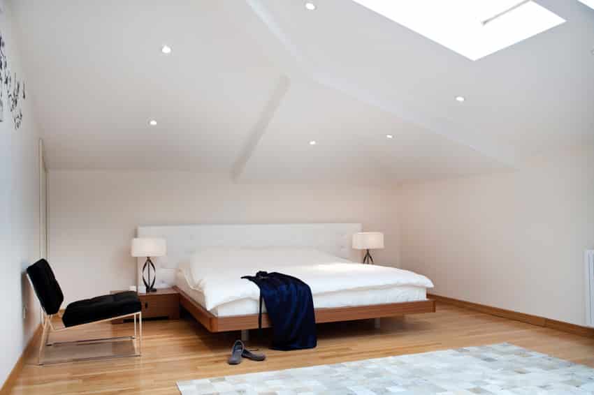 Minimalist bedroom with recessed lighting on angled ceiling