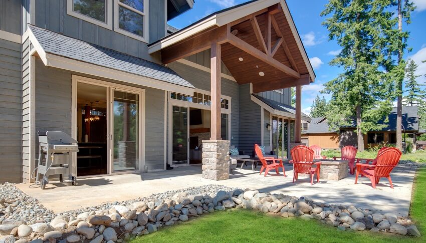 Modern and rustic home exteriors with shiplap siding post and beam in back yard view with fire pit and red chairs