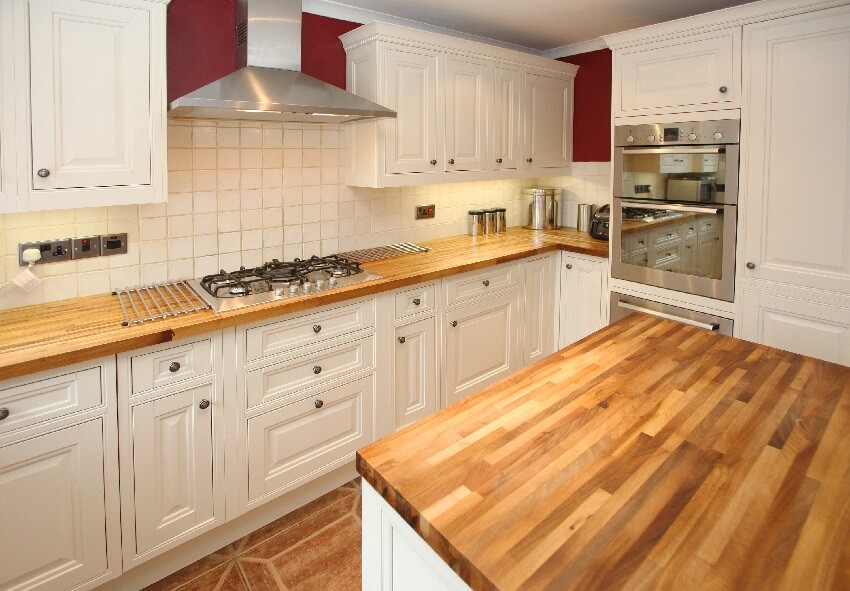 Cottage style kitchen with stainless steel appliance, burner cooktop and wood block island
