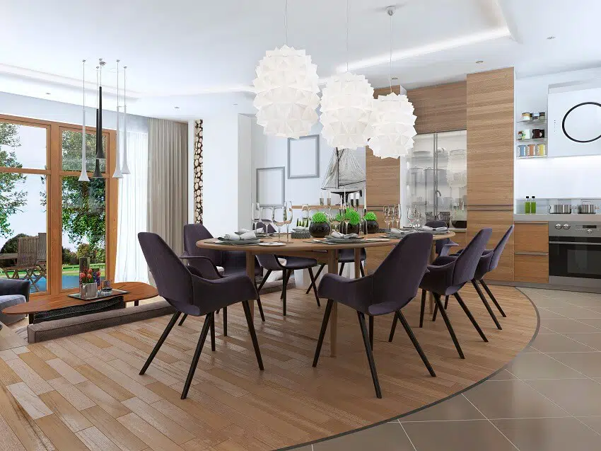 Modern dining area blending into the living room in a loft style with wood dining table and chairs tile and wood laminate floors and lighting fixtures