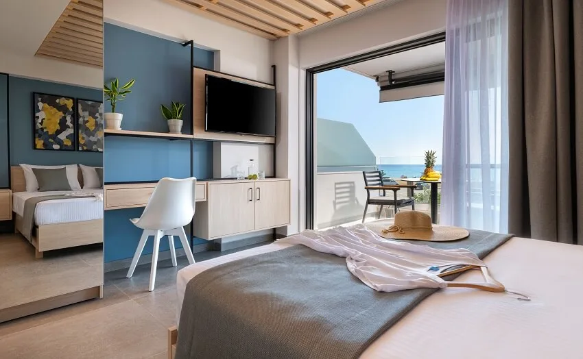 Modern loft style bedroom with tile floors ceiling wood panels wooden furniture mirror wardrobe abstract decor and open air french window terrace with sea view