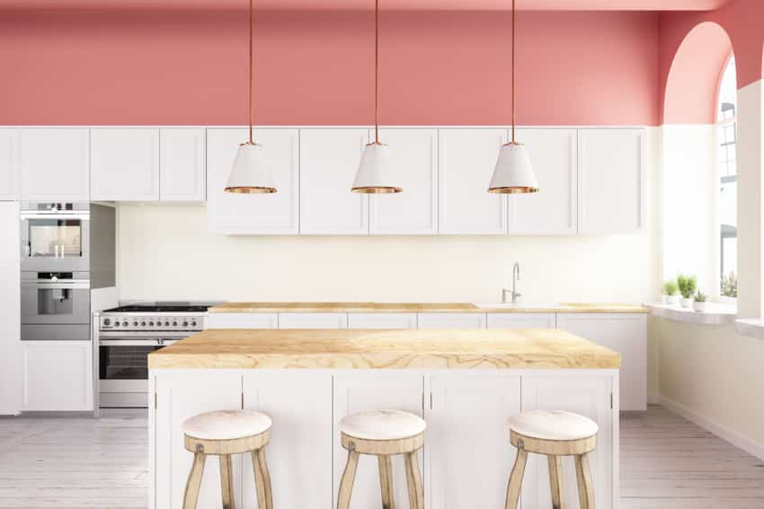 Pink and white kitchen multiple hanging lights window center island countertop cabinets