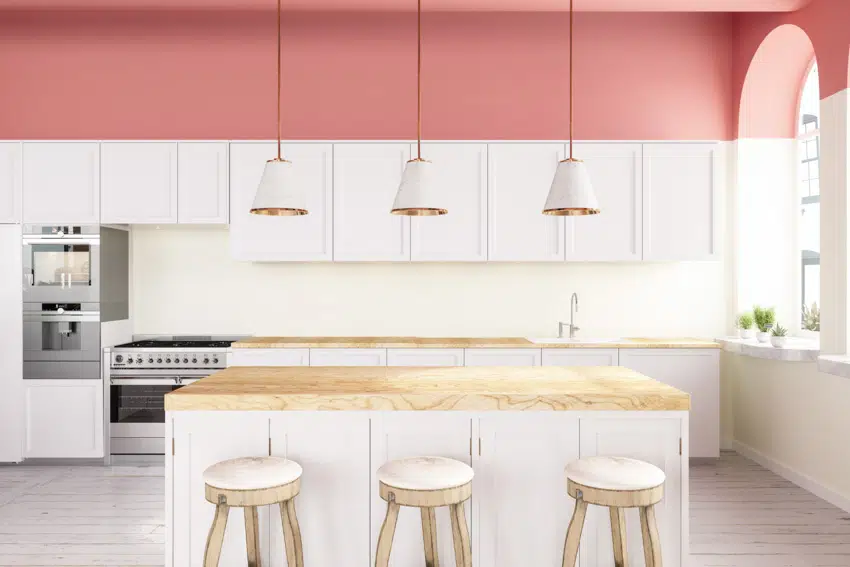 Pink and white kitchen with white and gold pendants