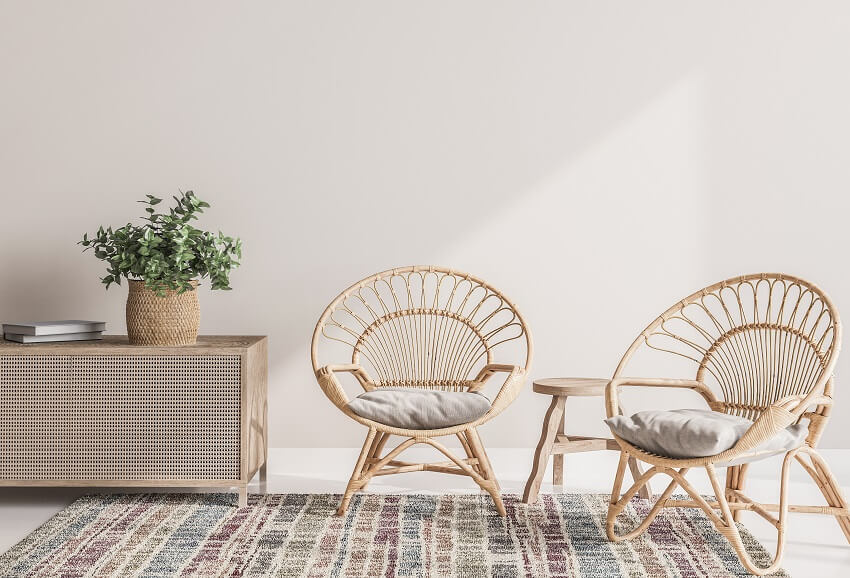 Room interior with empty white wall rug and wooden rattan armchairs with console and green plant