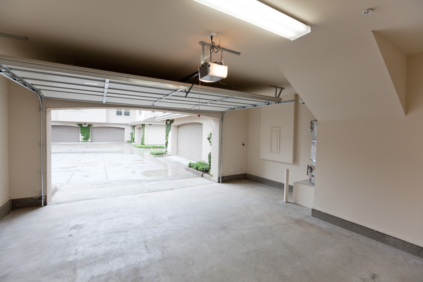 Open garage door, lighting fixture and beige walls