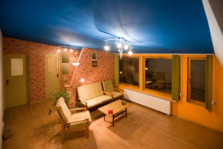Sloped blue ceiling track0lighting chair sofa wood flooring windows door