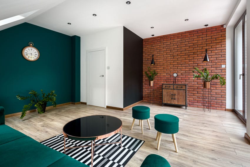 Living room with sloped ceilings, dark green accent wall and ceiling lights