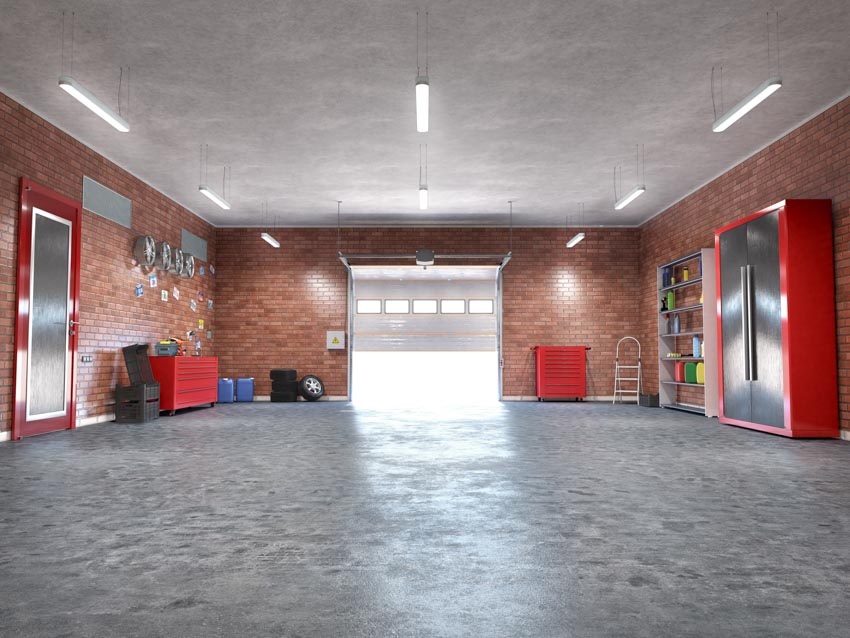 Garage with brick walls, sealed flooring and red door