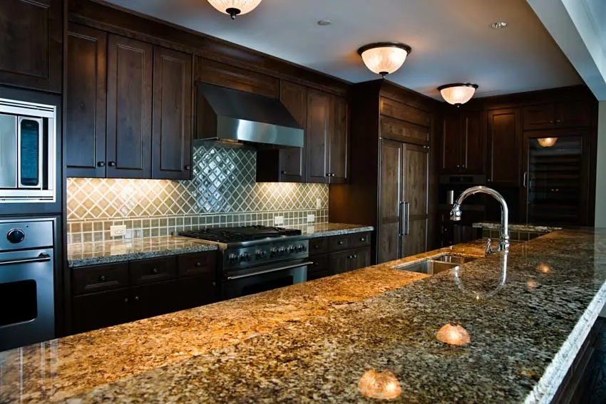 Translucent kitchen countertop center island wood cabinets sink tile backsplash ceiling light