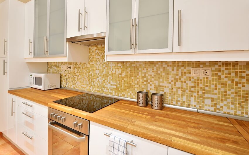 White kitchen with beech countertops and mosaic tile backsplash